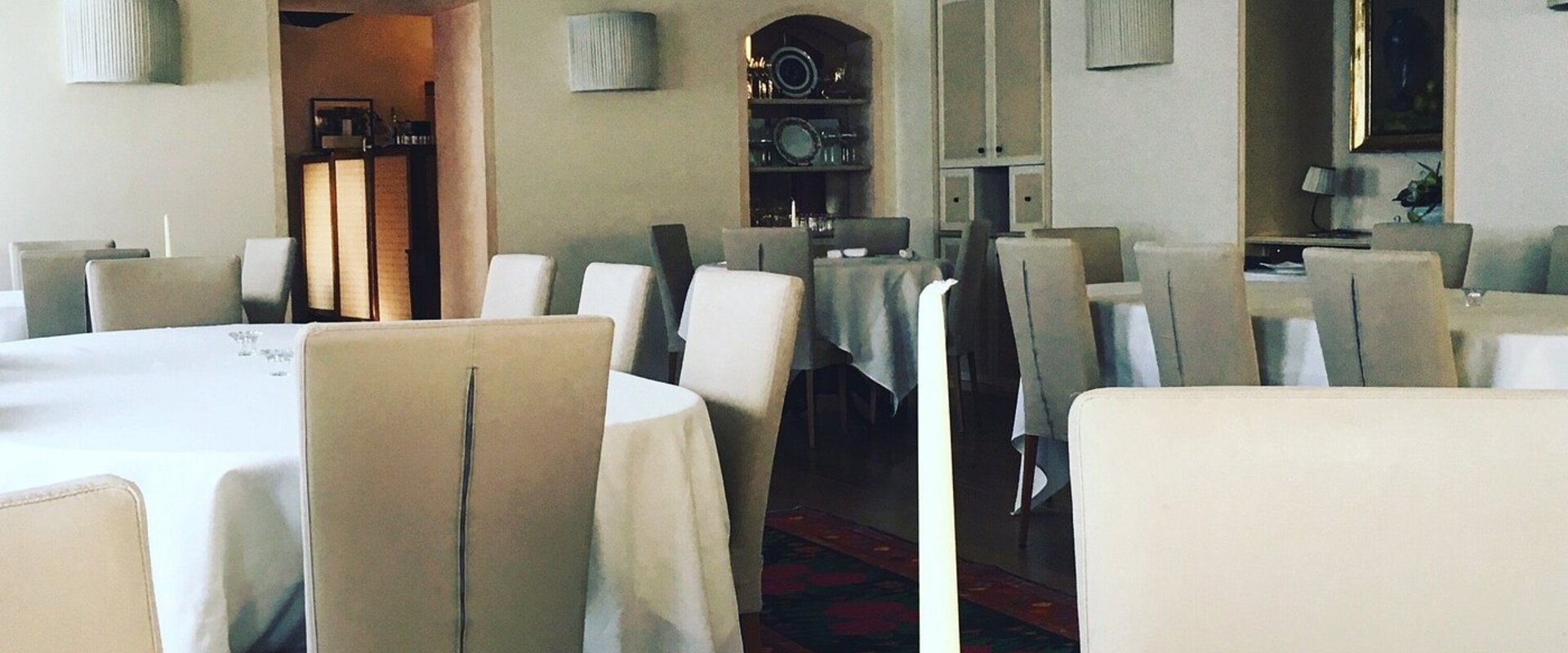 Antica Osteria dei Cameli ad Ambivere, sala elegante con archi in pietra e tavoli apparecchiati