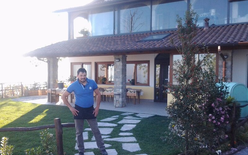 Sala rustica dell'agriturismo con tavolate in legno e camino acceso