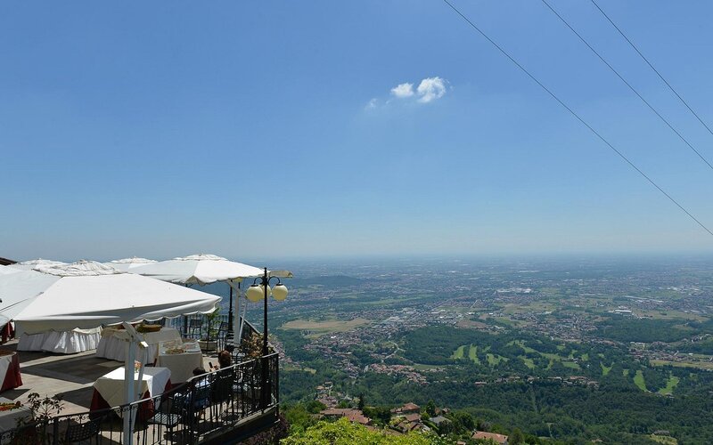 Sala principale con forno a legna a vista e tavoli per famiglie