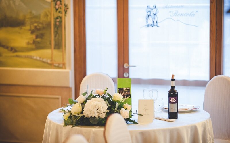 Sala interna del Ristorante Roncola con arredi sobri e tovagliato bianco